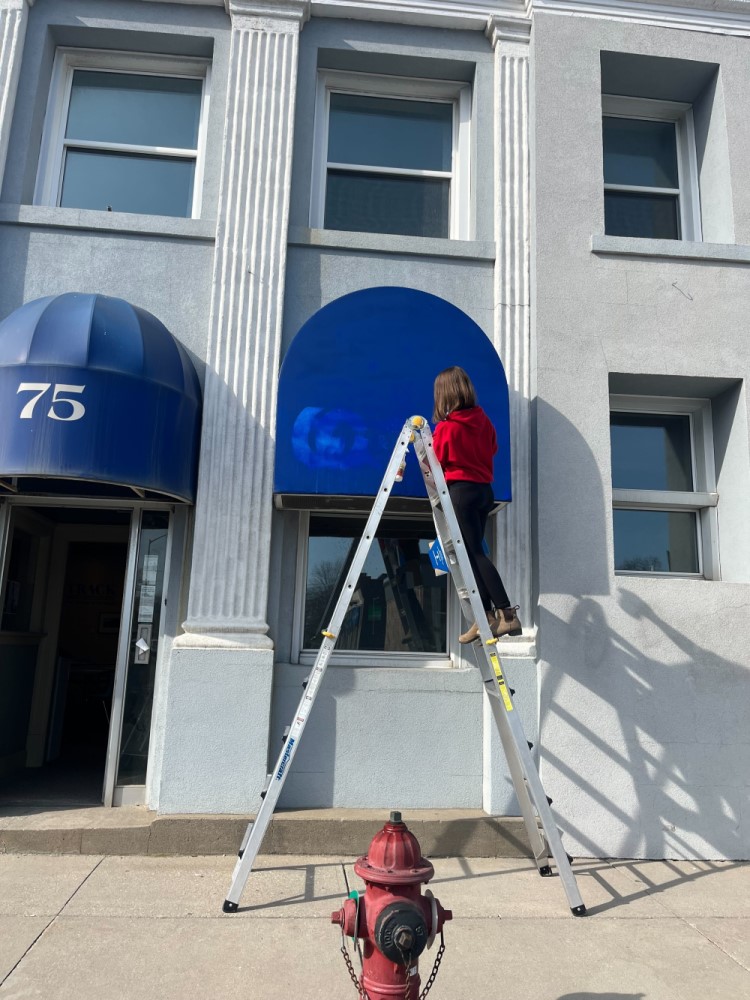 Collections Manager Sarah Bentley paints the awnings