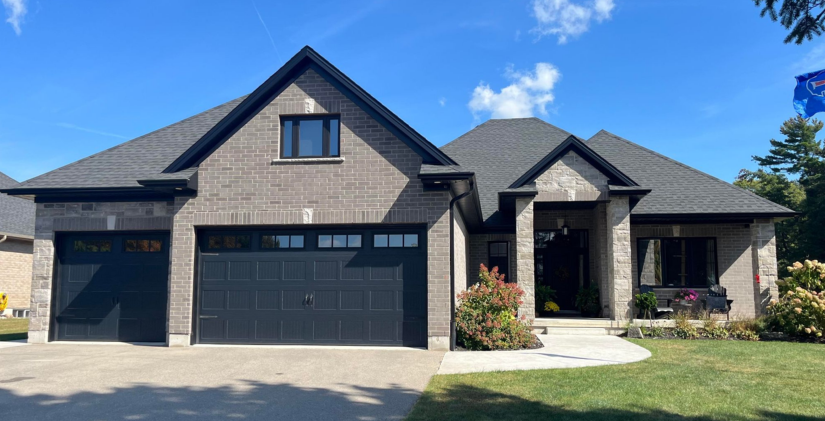 8394 Imperial Road. A single-storey grey brick farmhouse-style home, with a three-car garage.