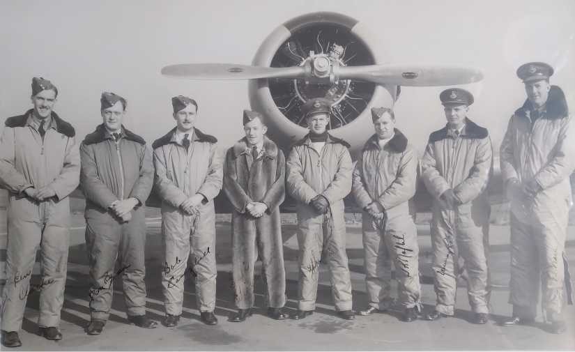 Image of a group of men in uniform standing in front of an aircraft