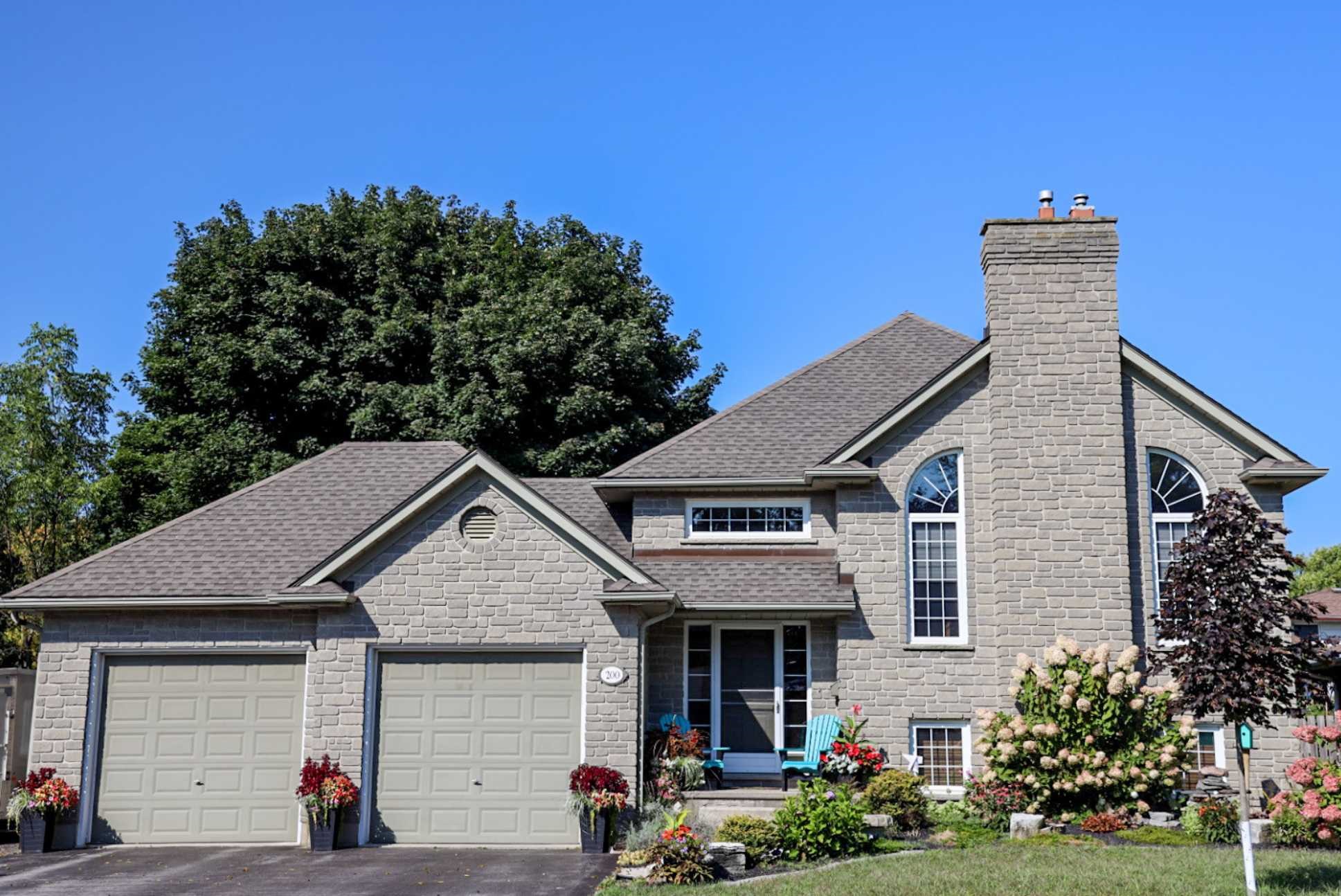 200 Caverly Road. A modern two-storey grey brick home with a double garage.