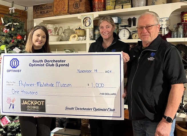 Image of three people holding a presentation cheque