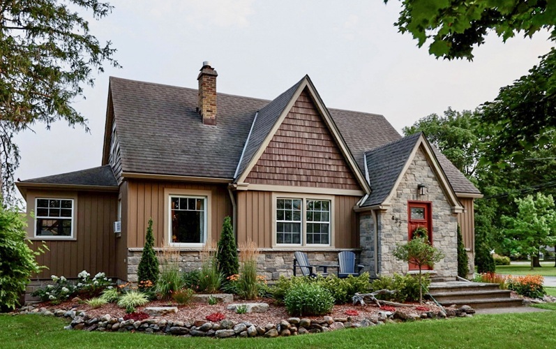 A one-storey home with a cobblestone entryway and well-tended garden